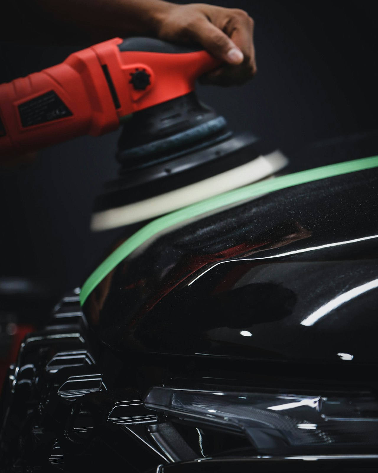 Dual-action polisher refining vehicle paint to remove swirl marks and restore gloss