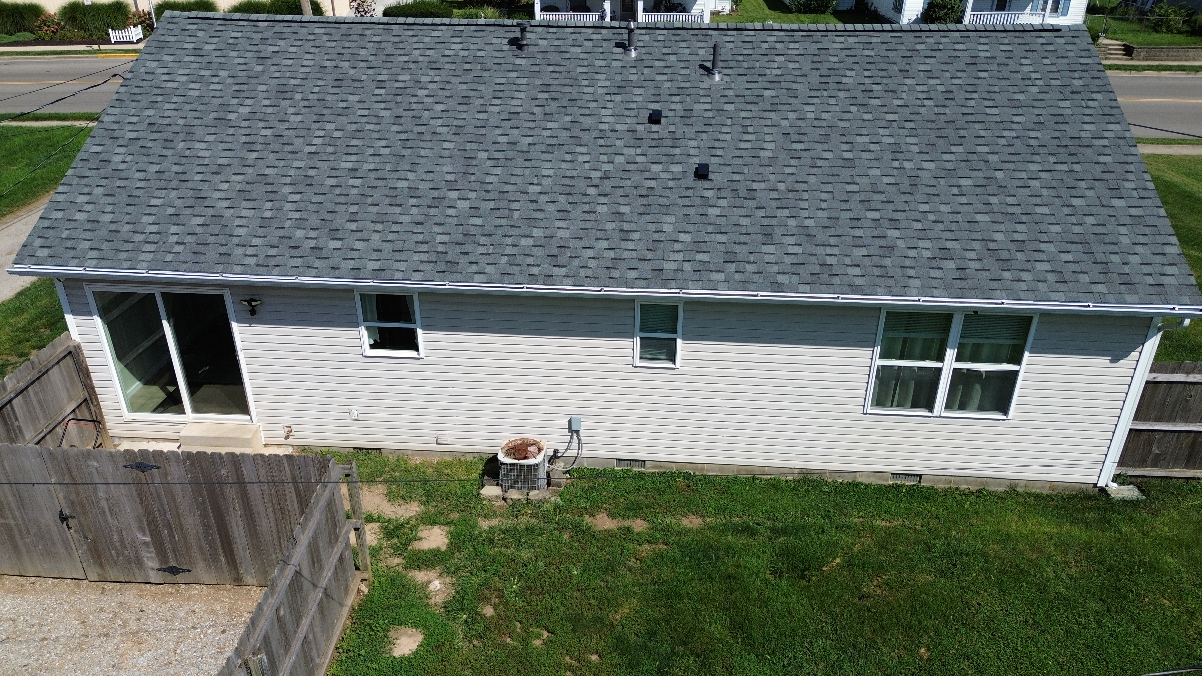 Aerial inspection of completed roof plane with ridge vent and clean perimeter