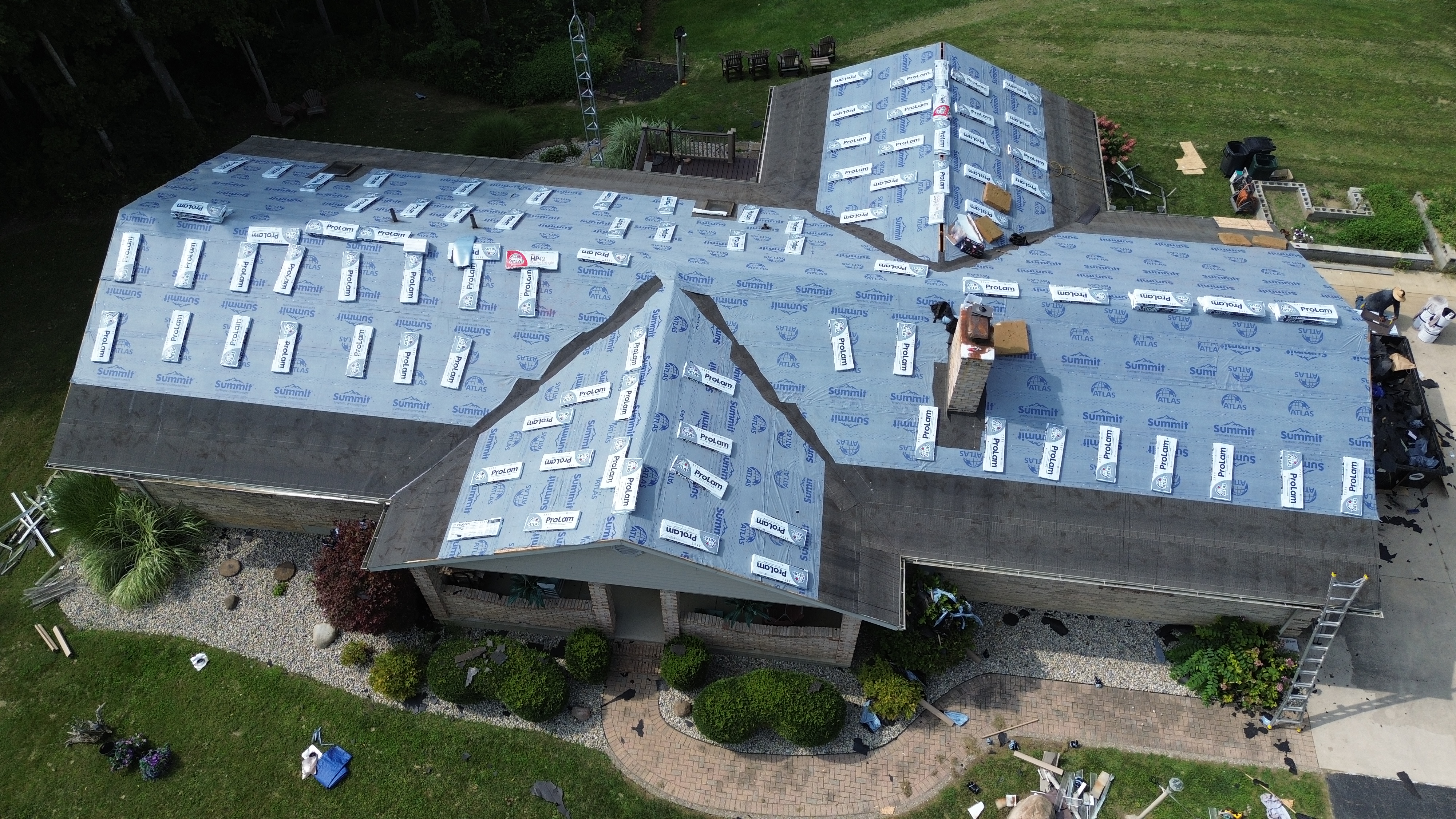 Drone aerial view of synthetic underlayment installation on residential roof