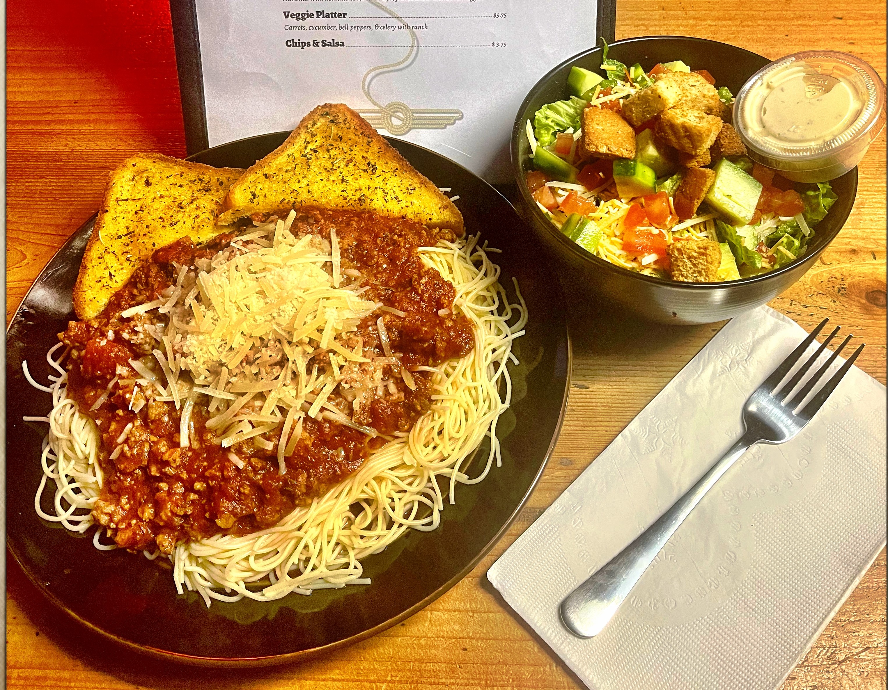 Wildhorse Bar & Grill Thursday special spaghetti dinner with hearty meat sauce, shredded cheese, toasted garlic bread, and a crisp side salad