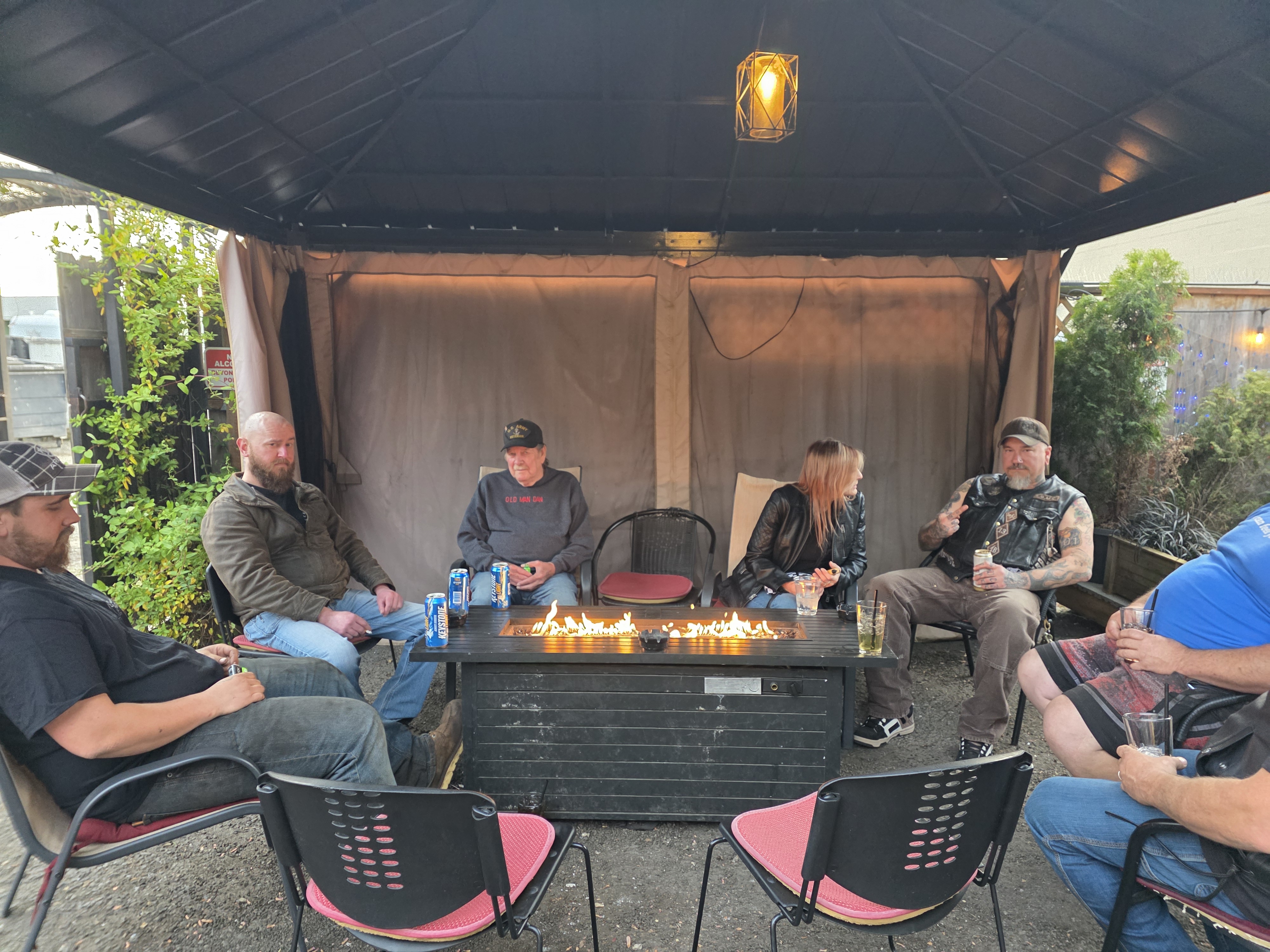 Wildhorse Bar & Grill outdoor patio at night, warm string lights and a fire-pit gathering under the covered Molalla patio.