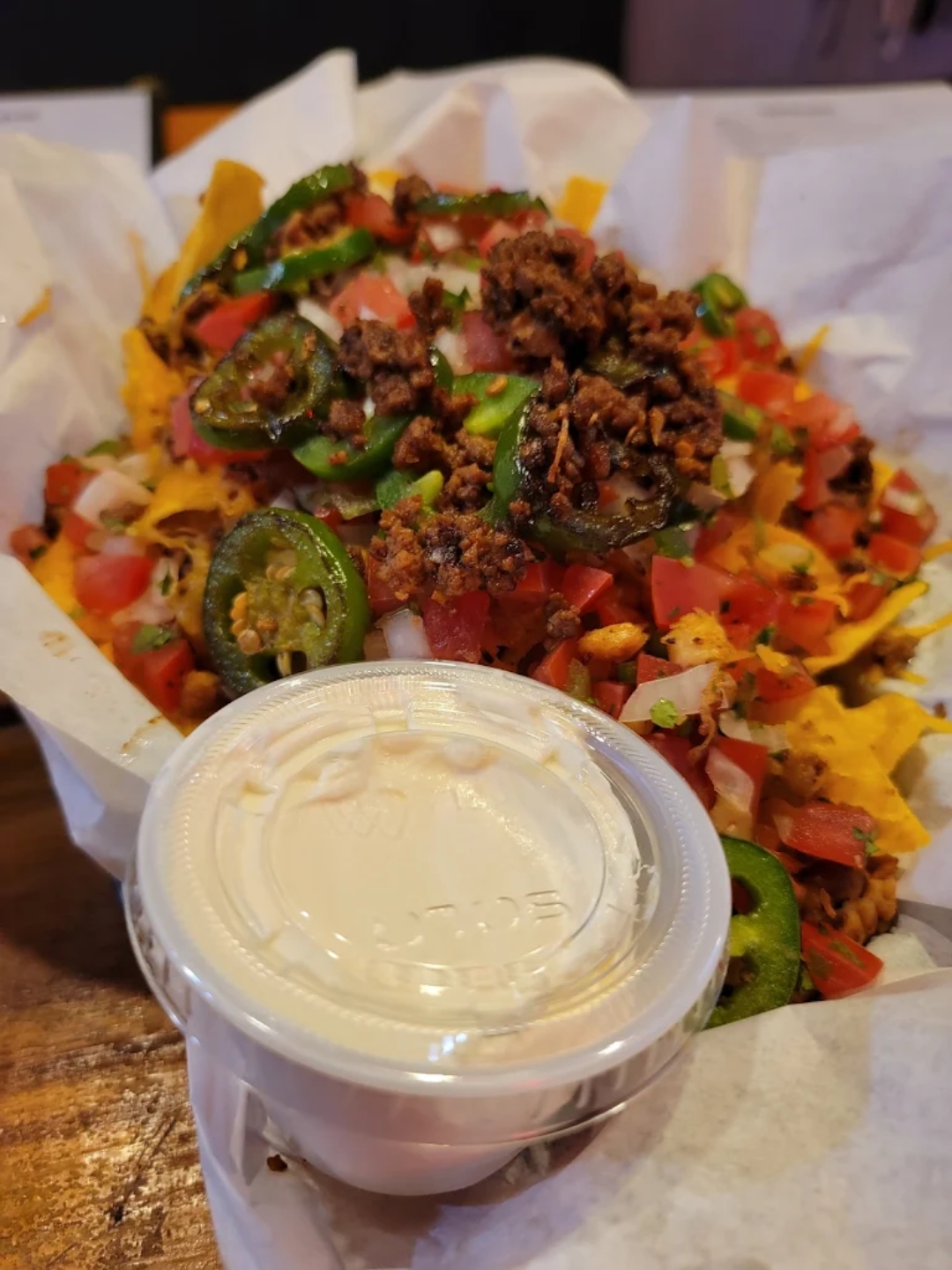 Wildhorse Bar & Grill Rodeo Nachos piled high with tortilla chips, melted cheese, seasoned ground beef, fresh pico de gallo, grilled jalapeños, and side of sour cream