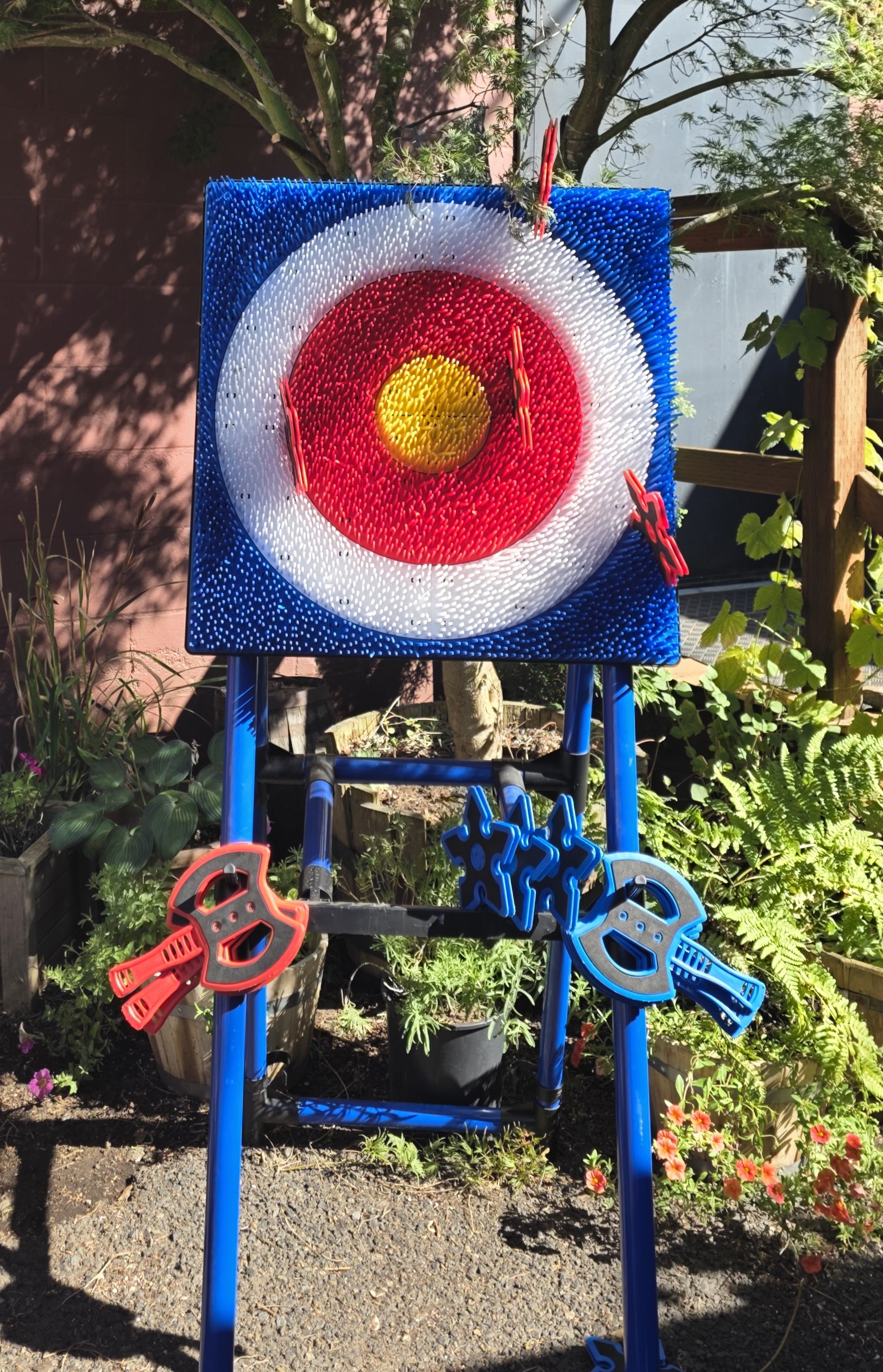 Wildhorse Bar & Grill outdoor patio bristle target axe throwing stand with red and blue safety throwing axes and stars