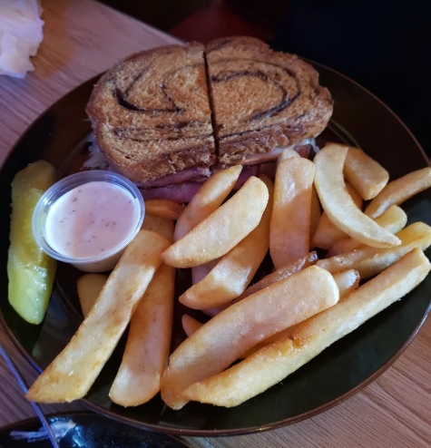 Wildhorse Bar & Grill Friday special The Reuben sandwich on grilled marble rye served with thick-cut steak fries, pickle spear, and dipping sauce