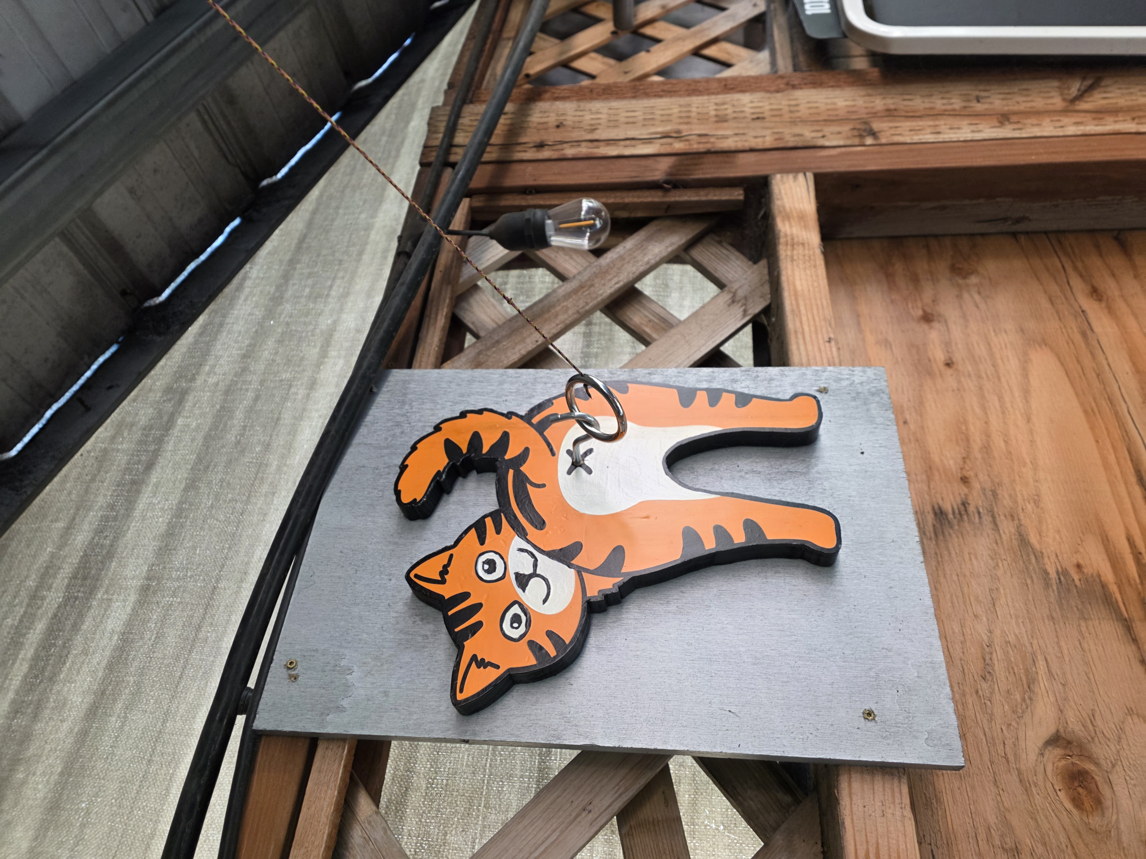 Wildhorse Bar & Grill outdoor patio Hook and Ring swing toss game featuring custom cat target and ring on a string