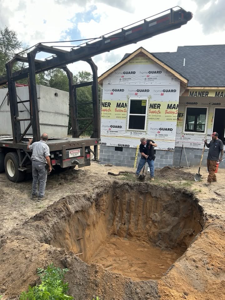 Rosier field crew setting septic tank with heavy boom truck equipment