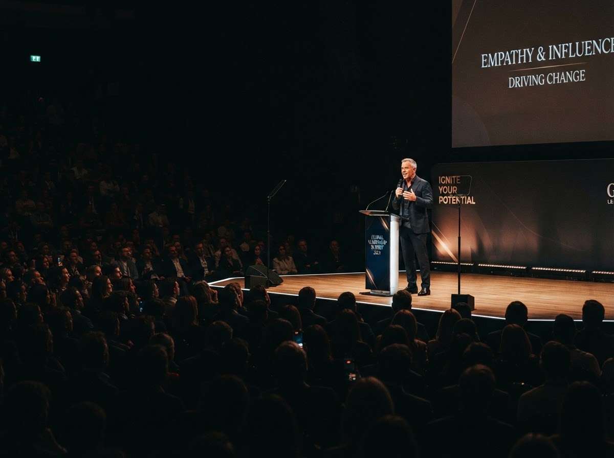 A speaker addressing an attentive audience from a lit stage