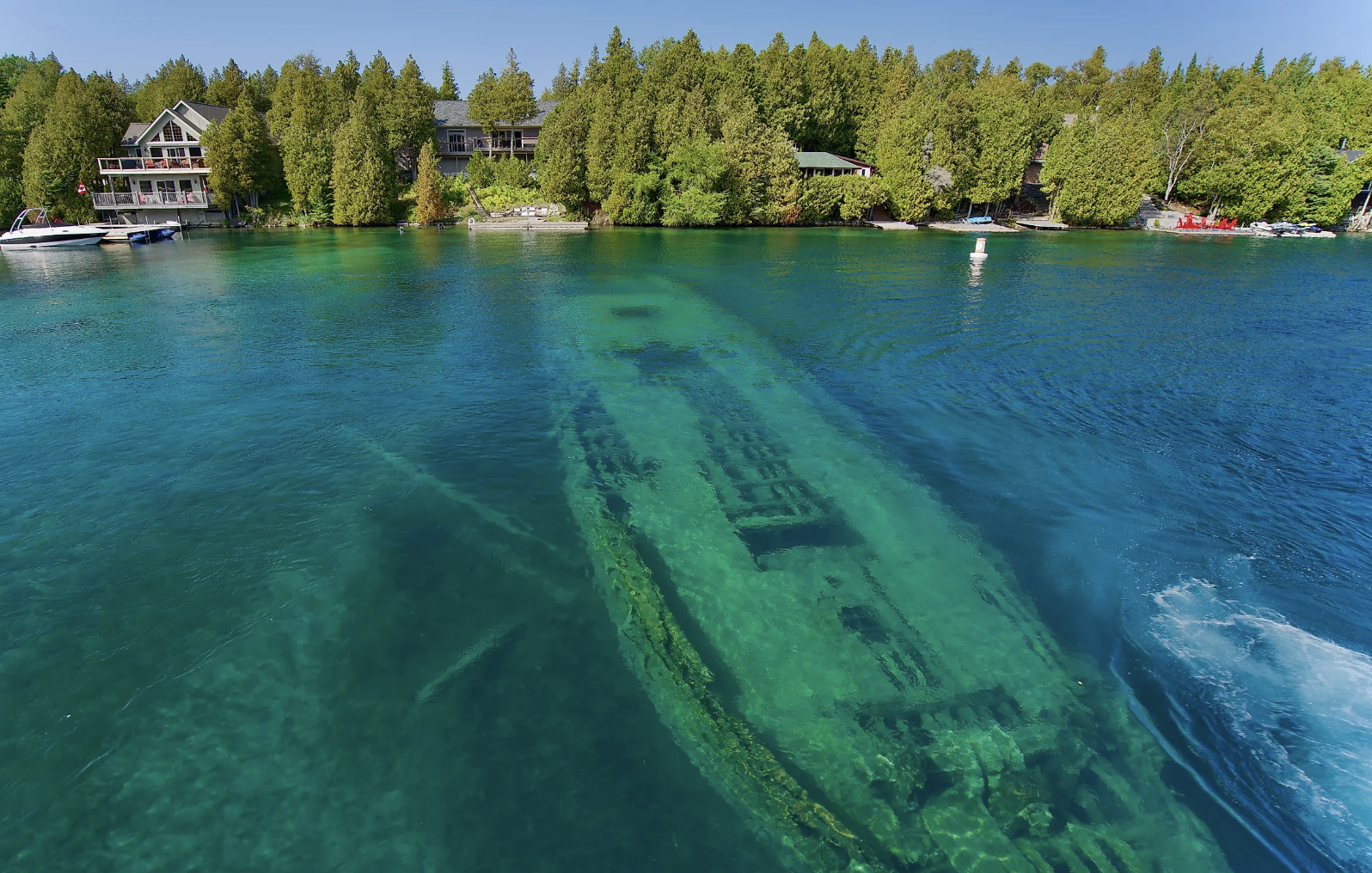 Crystal clear emerald waters of Tobermory and Big Tub Harbour showing historic sunken shipwreck