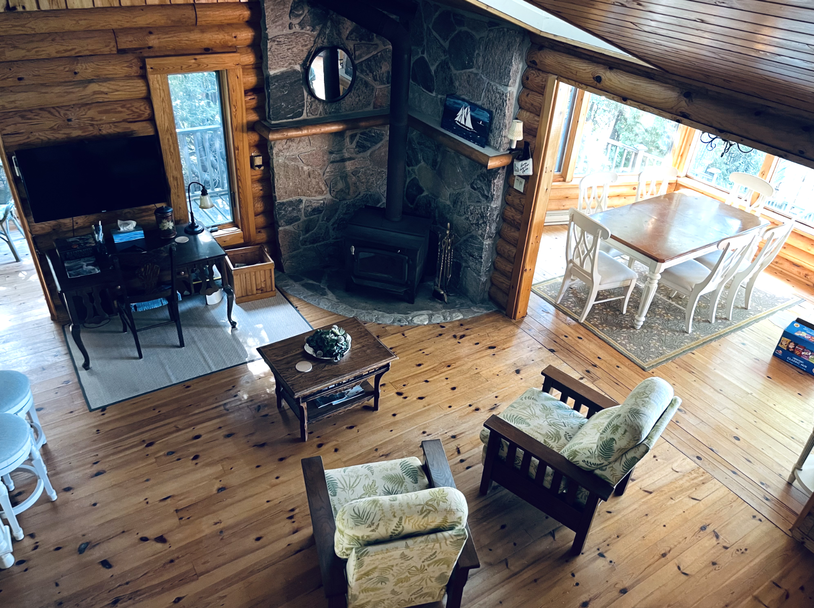 High-angle view of the lodge great room with wood stove fireplace, seating, and dining area