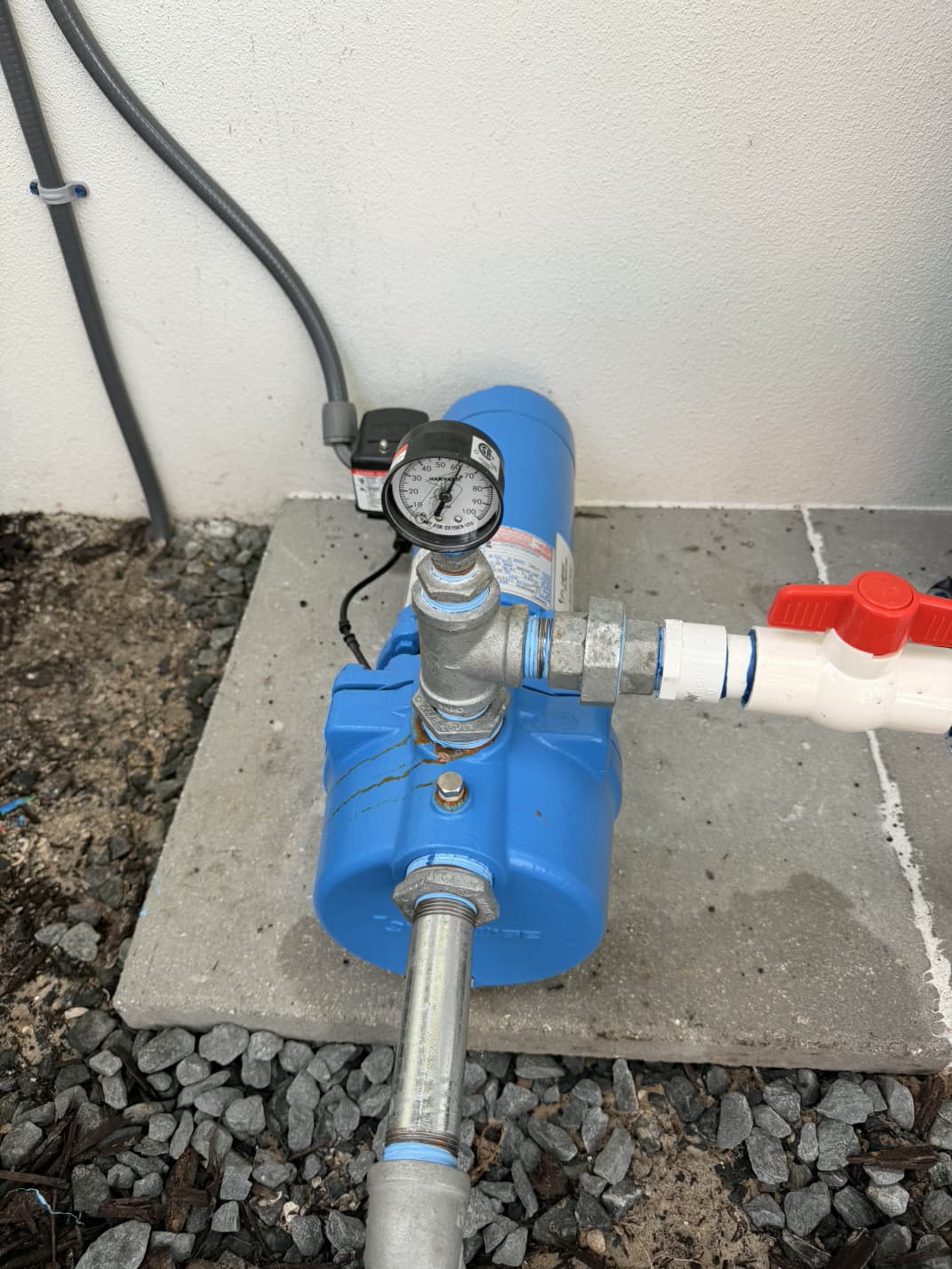 blue Goulds irrigation booster pump with pressure gauge and shut-off valve on concrete pad