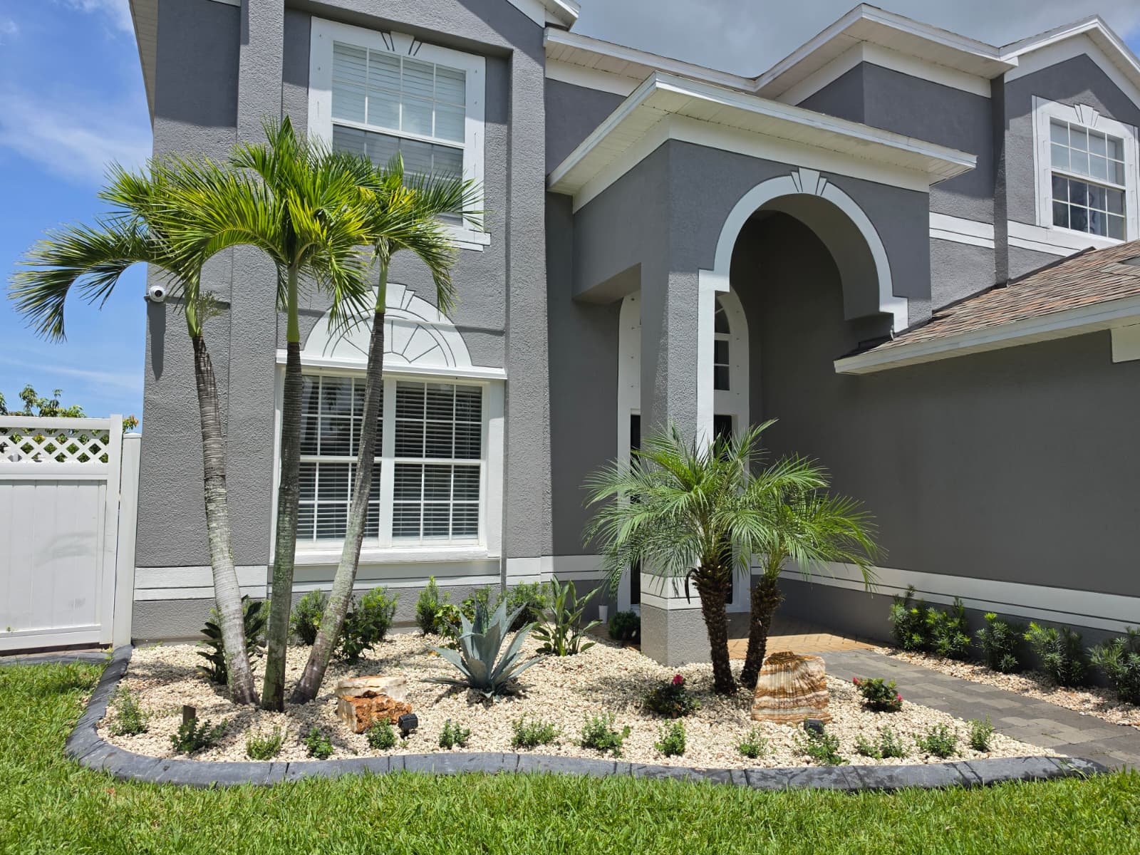 tropical palm garden design with rock edging completed by Aenlle Home Service LLC in Sarasota FL