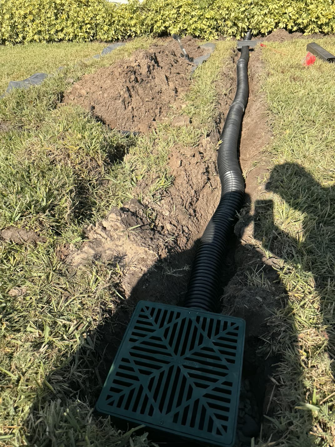 subsurface lawn French drain and NDS catch basin trench installation in residential turf by Aenlle Home Service LLC