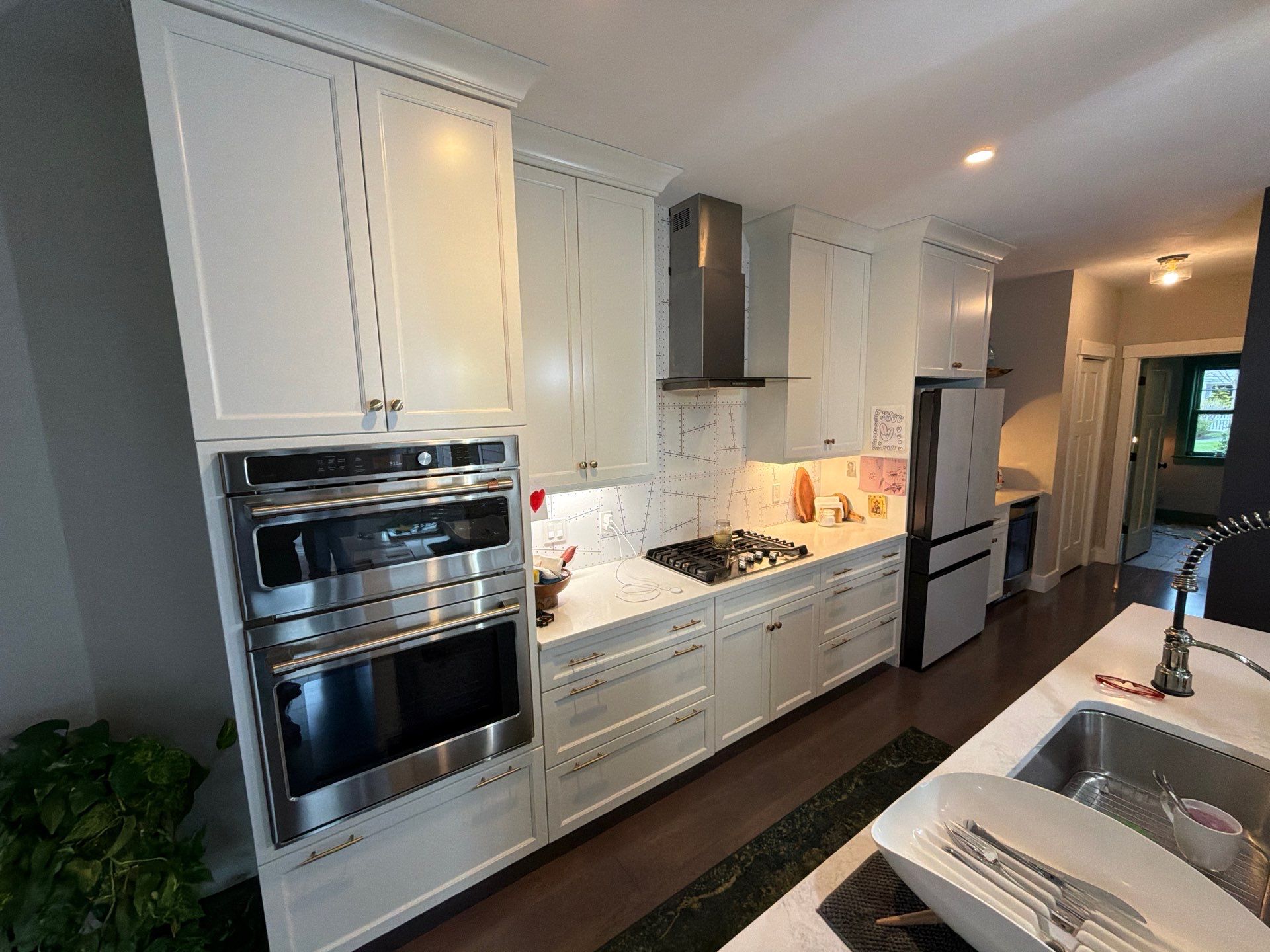 Before cabinet transformation: dated white kitchen cabinets and double wall oven suite
