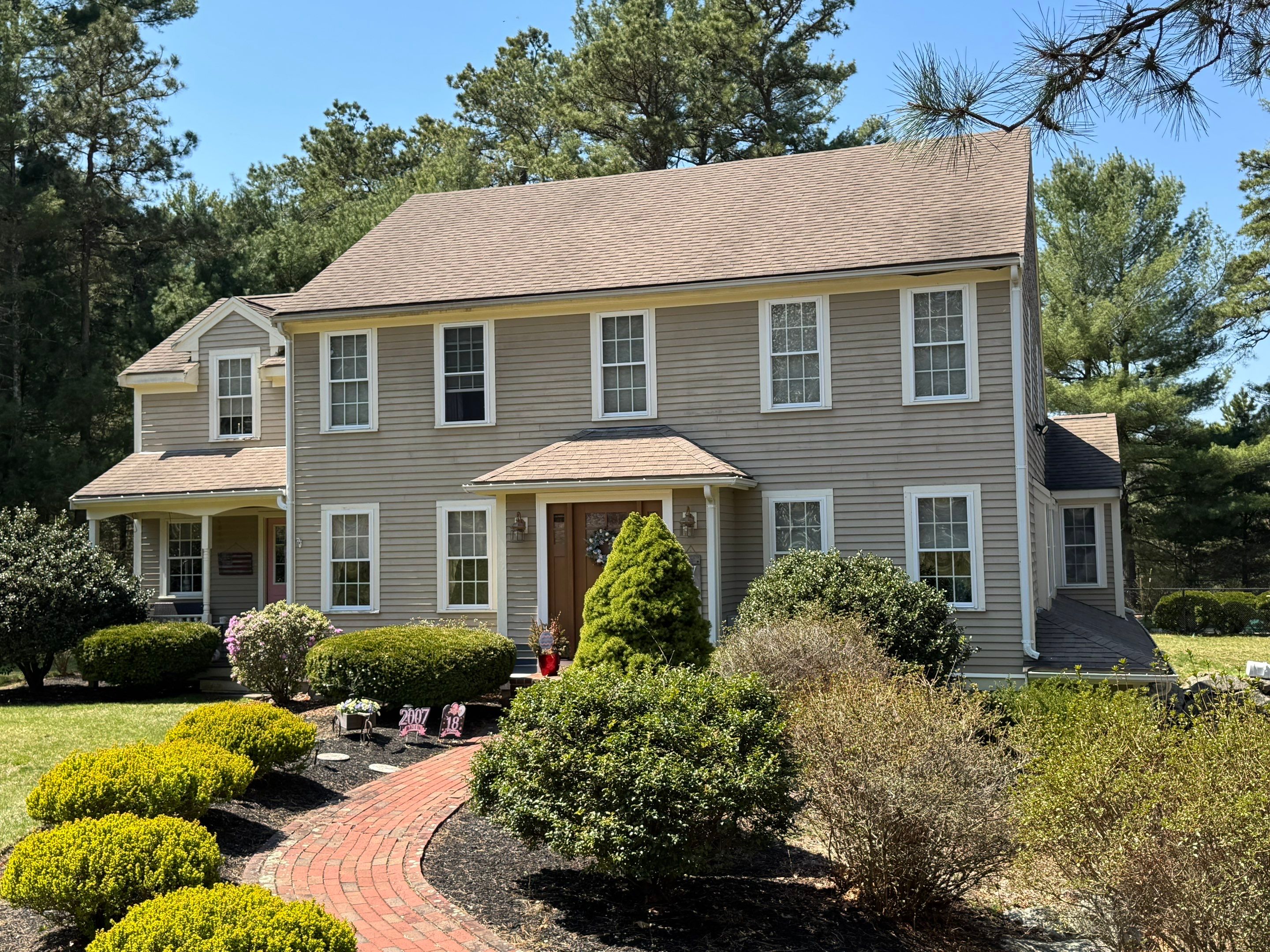 Before painting: weathered beige siding on two-story Massachusetts colonial home with dated tan trim