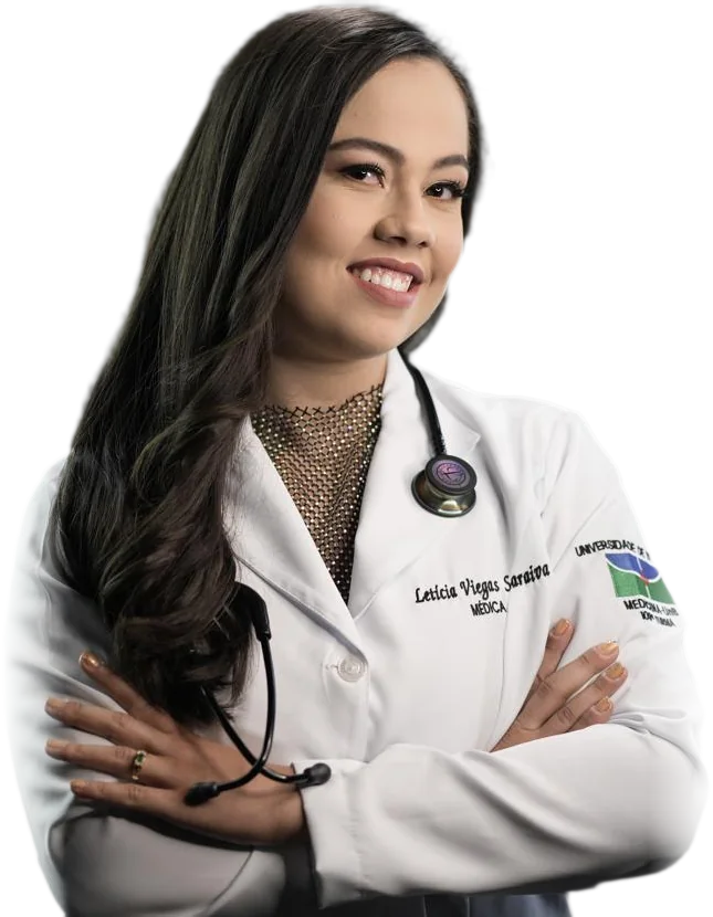 Dra. Letícia Viegas de braços cruzados, de jaleco da Medicina UnB e estetoscópio, sorrindo