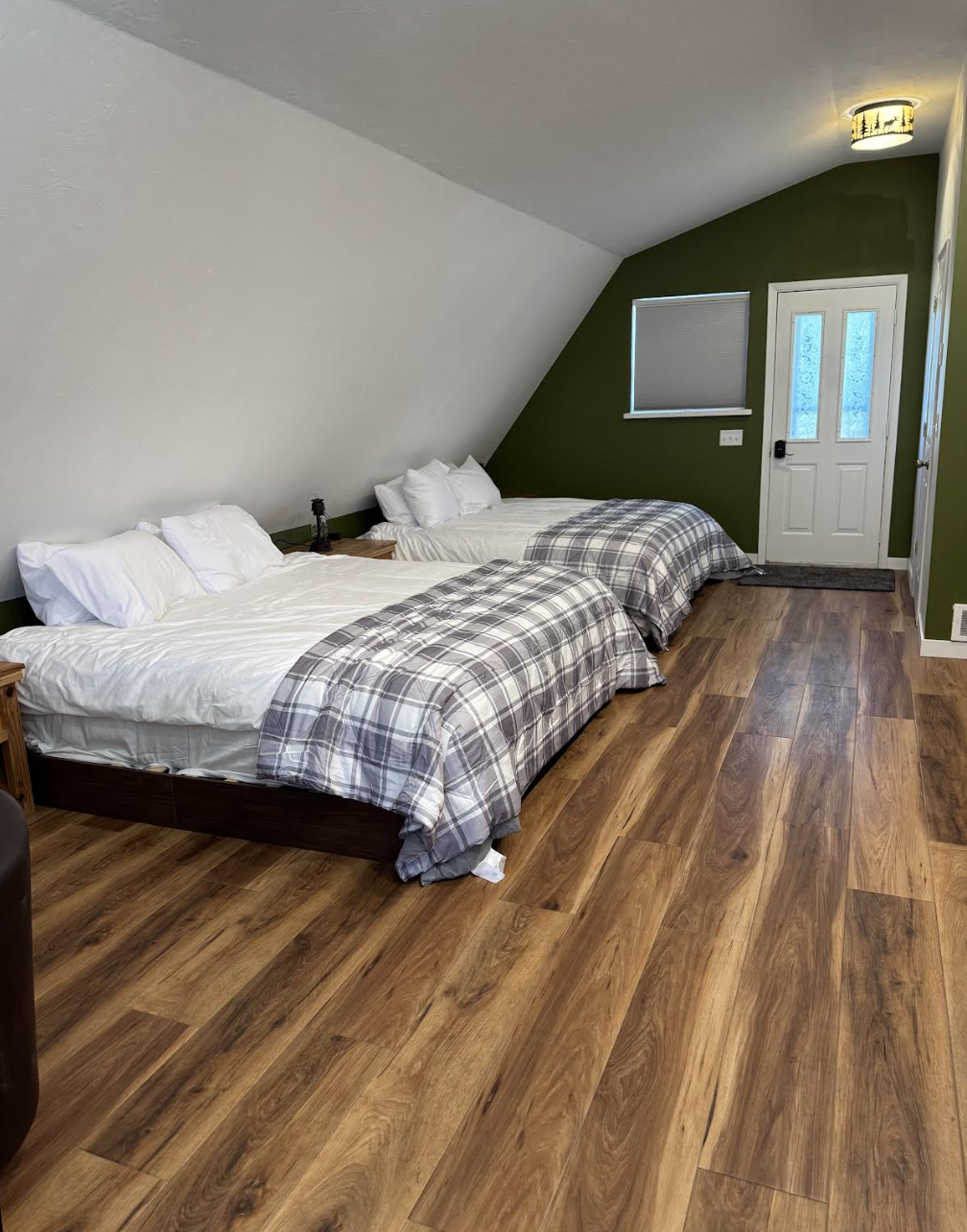 Upstairs loft bedroom with comfortable king beds and green accent wall