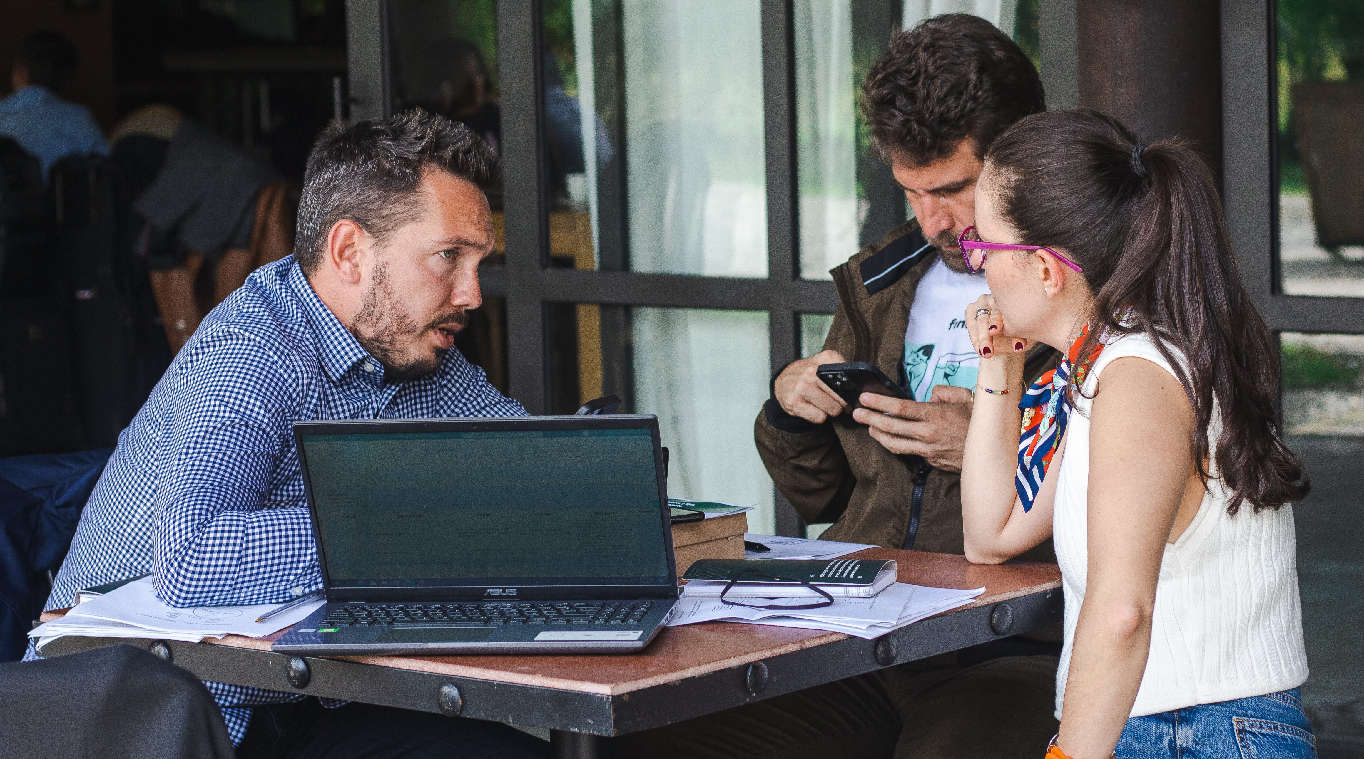 Participantes revisando material y casos previos con computadora