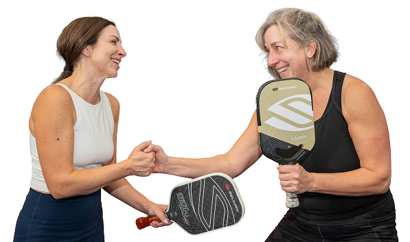 Two players fist-bumping on the court at Pickleplex Social Club