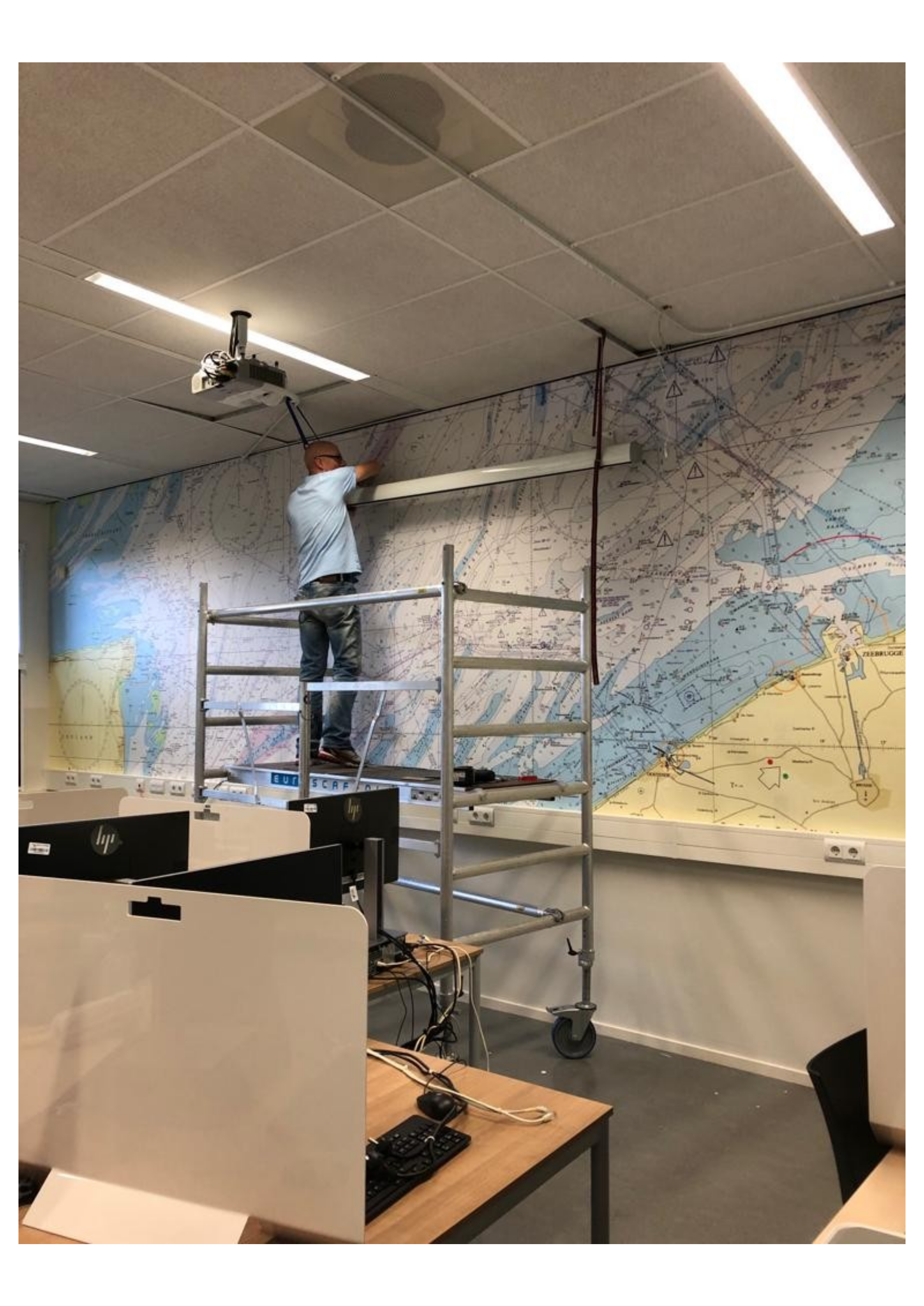 Naadloze fotowand montage op rolsteiger in kantooromgeving
