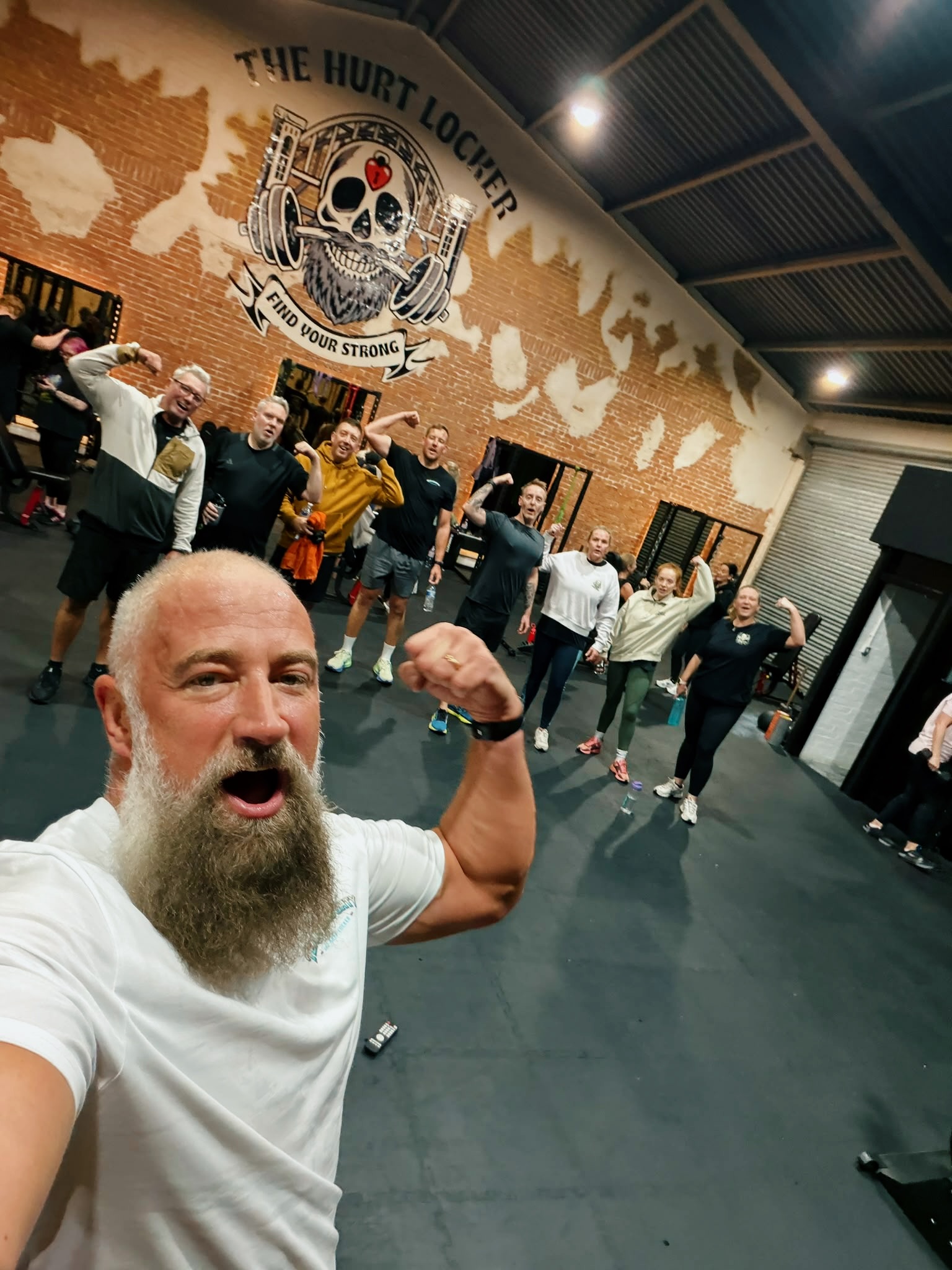 Davie and members celebrating on the gym floor at The Hurt Locker