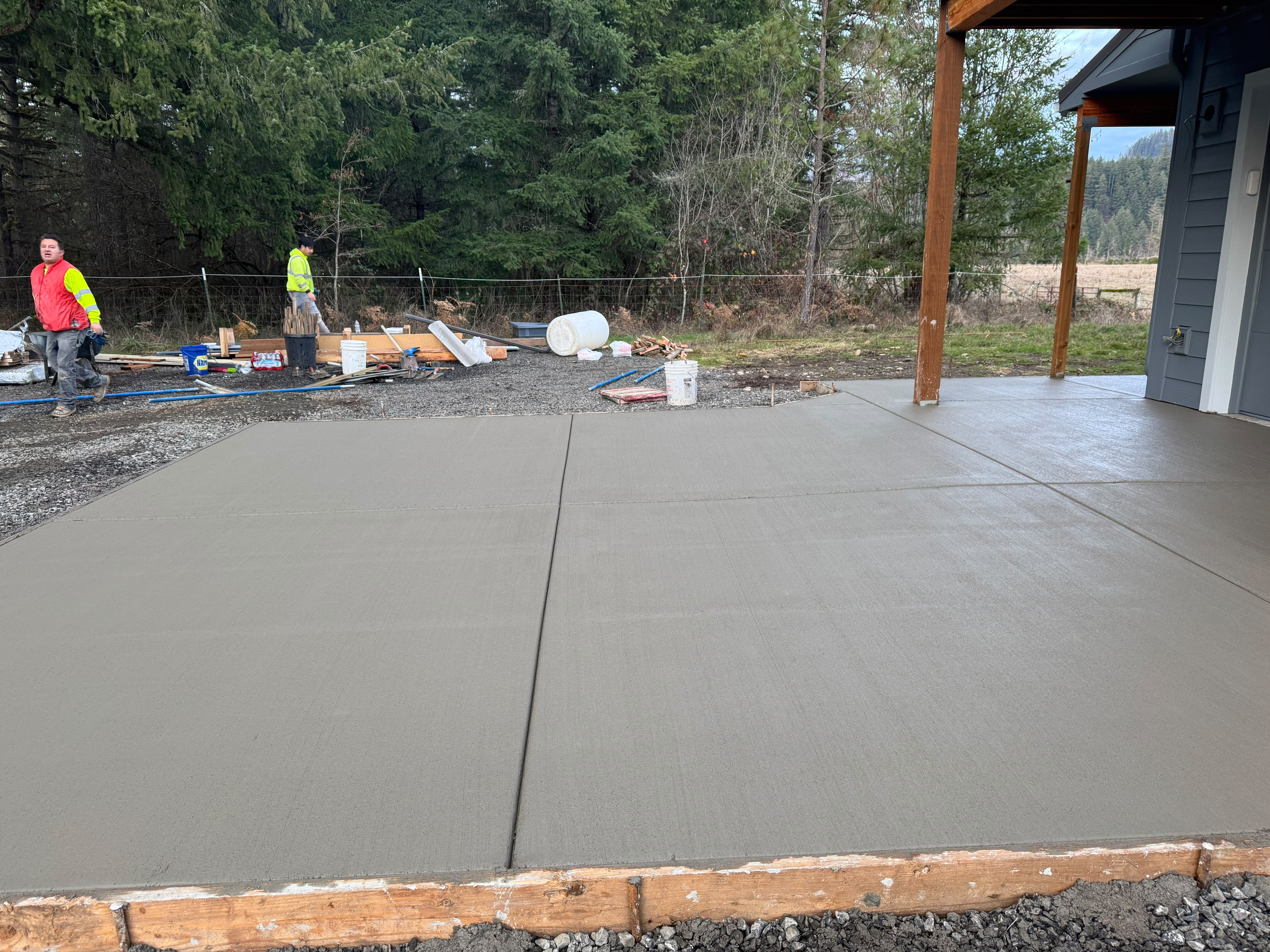 newly poured covered backyard concrete patio with post integration and tooled control joints in Oregon by Foothills Concrete LLC