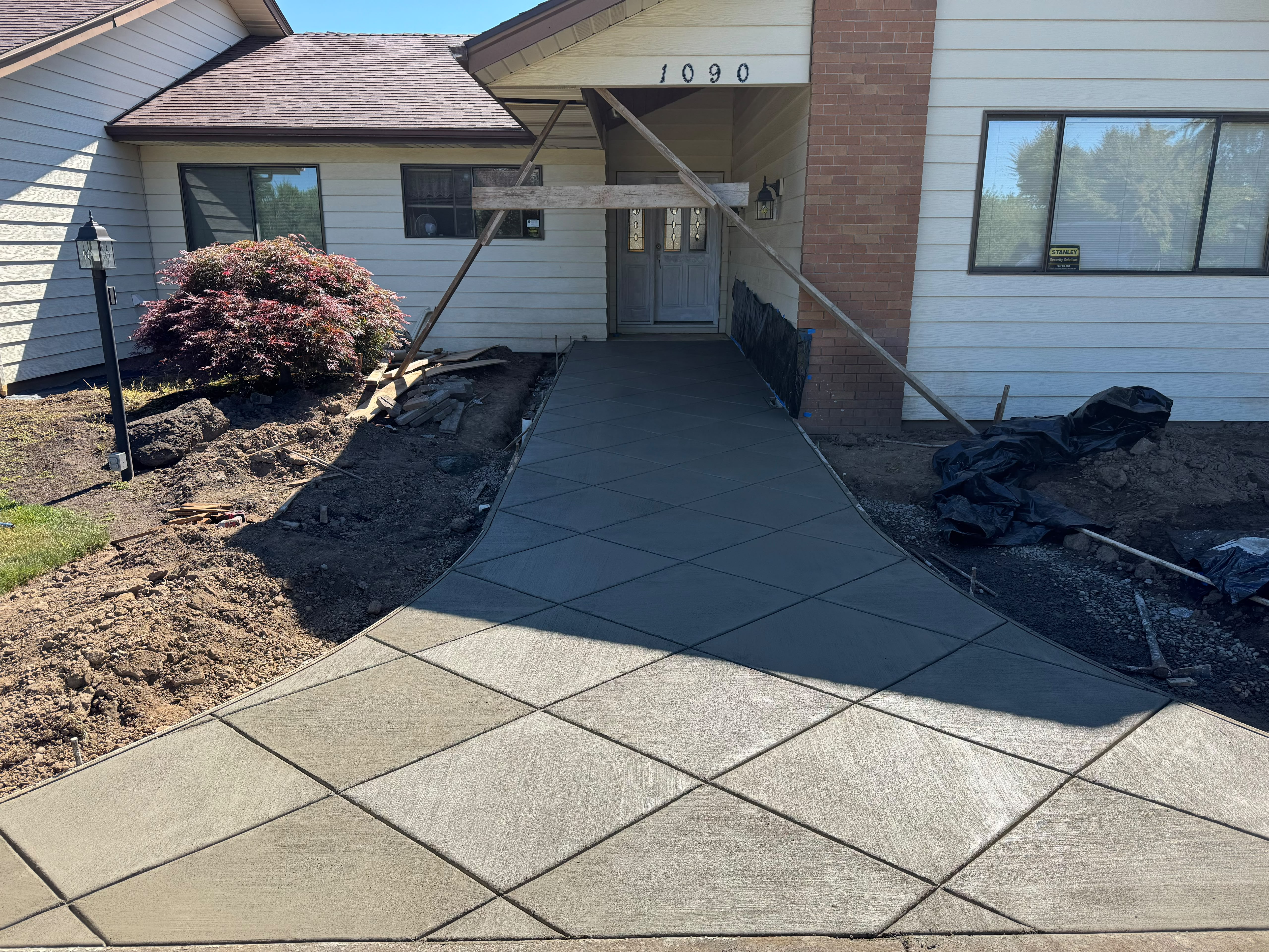 Custom diamond pattern scored concrete front entry walkway installed by Foothills Concrete LLC