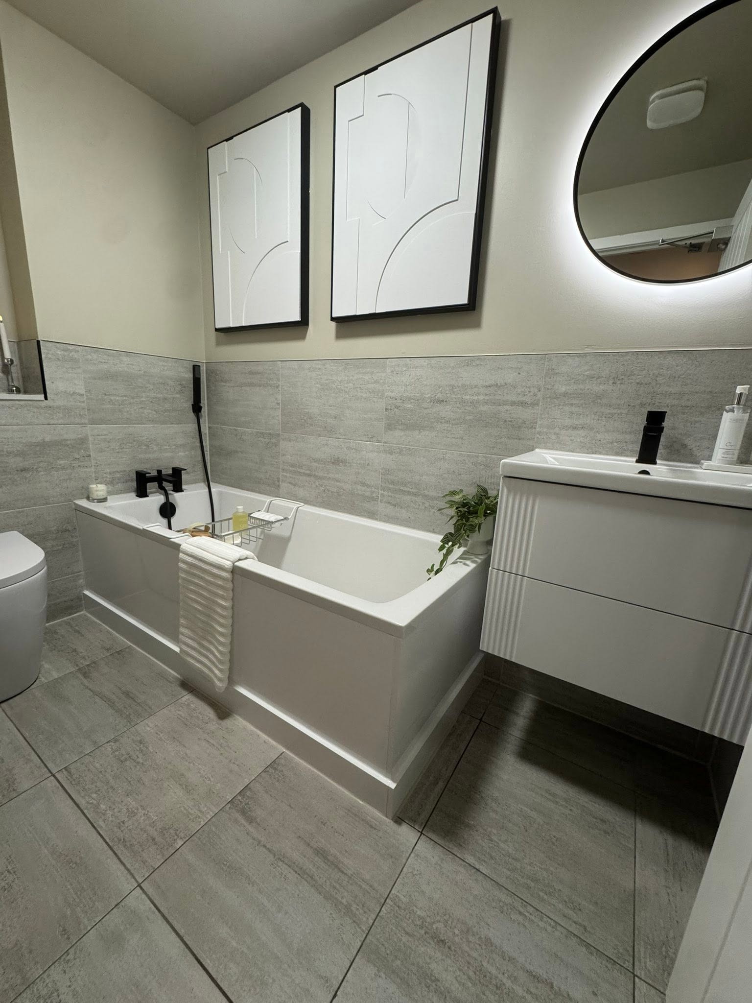 Contemporary tiled bathroom refit with floating vanity, LED mirror and matte black fixtures by Diamond Kitchens & Bathrooms