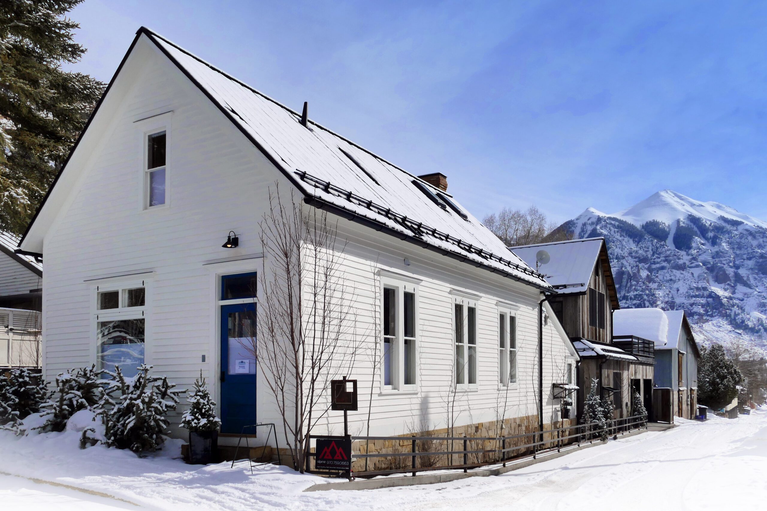 Restored historic Telluride home framed by snow-covered mountain peaks
