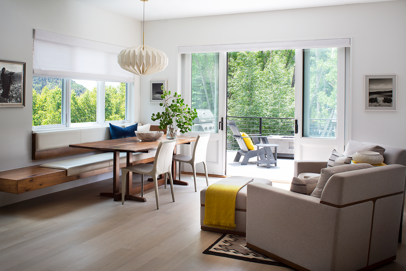 Sunlit mountain residence dining area and living room opening to mountain terrace by Shift Architects