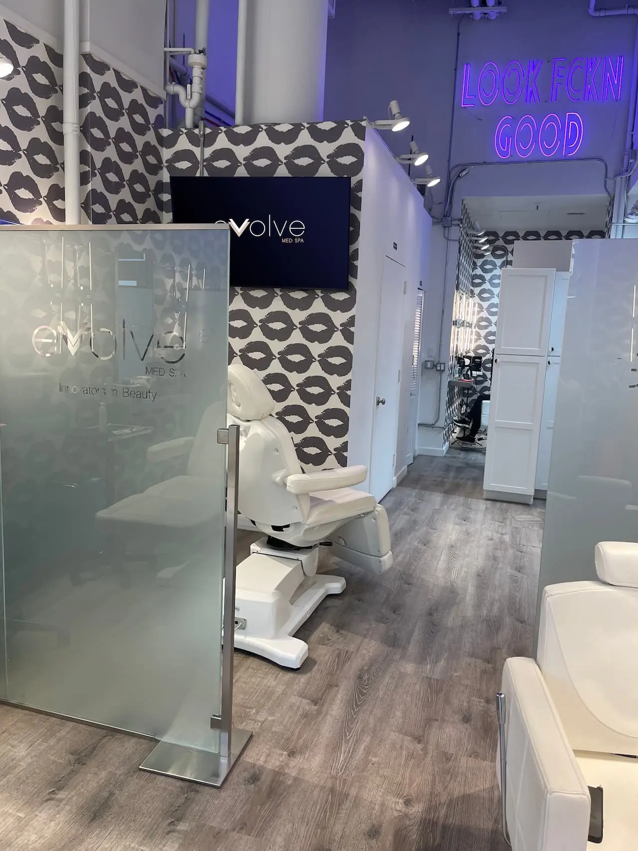 Modern medical aesthetics clinic treatment room with clinical chair and private partitions