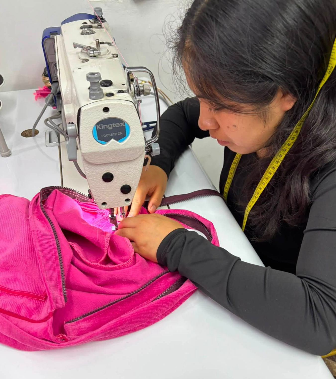 Alumna cosiendo en máquina Kingtex en Apega Milenium