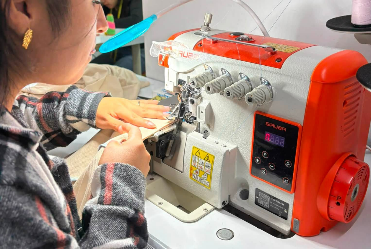 Alumna cosiendo en máquina industrial Siruba con luz LED en Apega Milenium