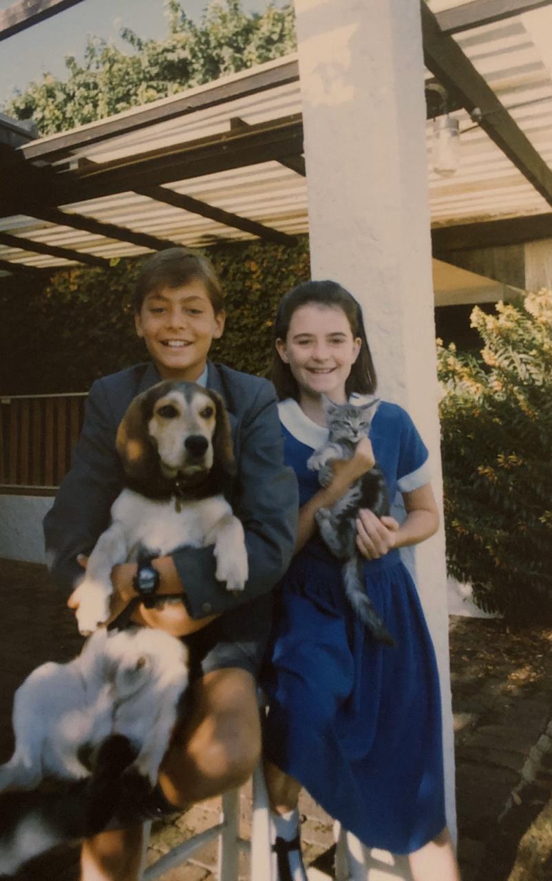 Lalena as a child in South Africa with her brother, holding their dog and kitten