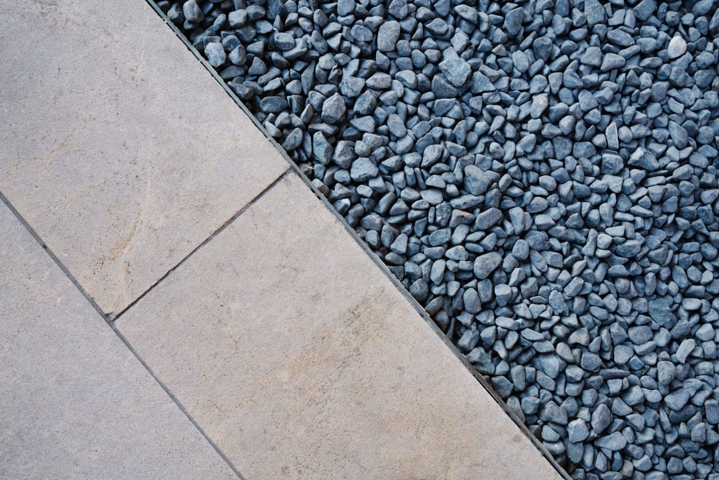 Clean stone slabs laid with contemporary grey stone gravel border by Multi Purpose Home Improvements