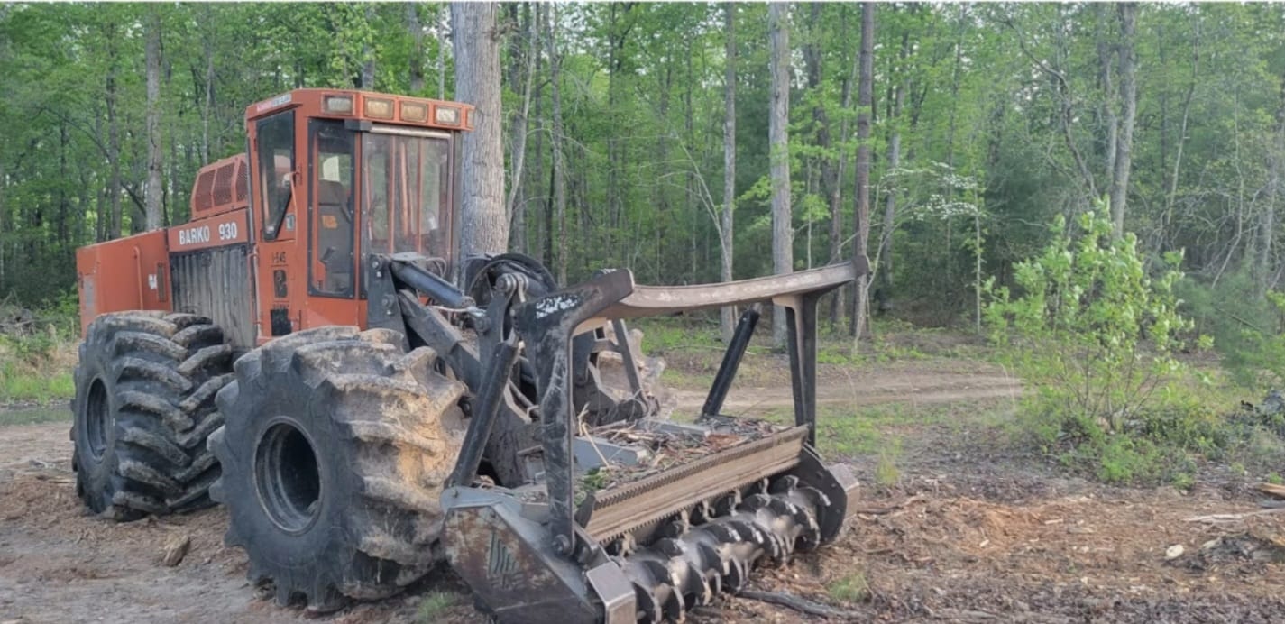 Heavy-duty Barko 930 industrial land-clearing machine equipped with mulching head in a wooded area