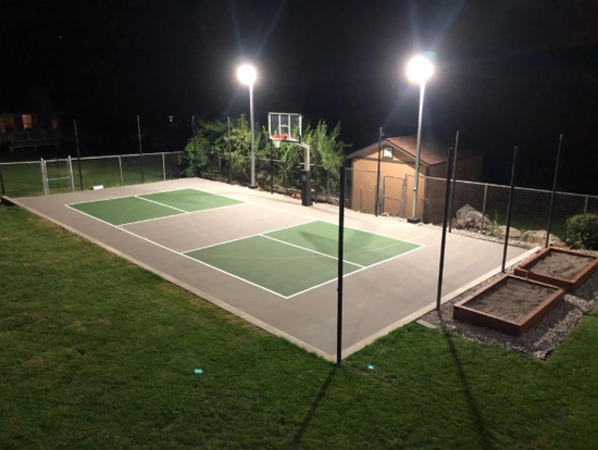 Lighted outdoor sport court glowing at night with green and gray playing areas after a court builder service in Henderson, NV