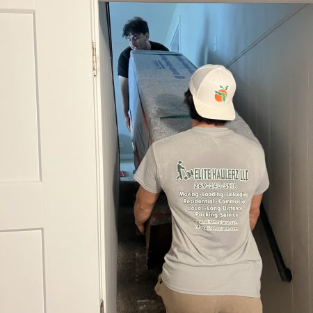 Movers carrying heavy furniture safely down tricky tight staircase