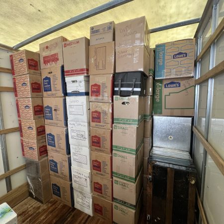 Tight floor-to-ceiling box stacking securing fragile cargo in truck