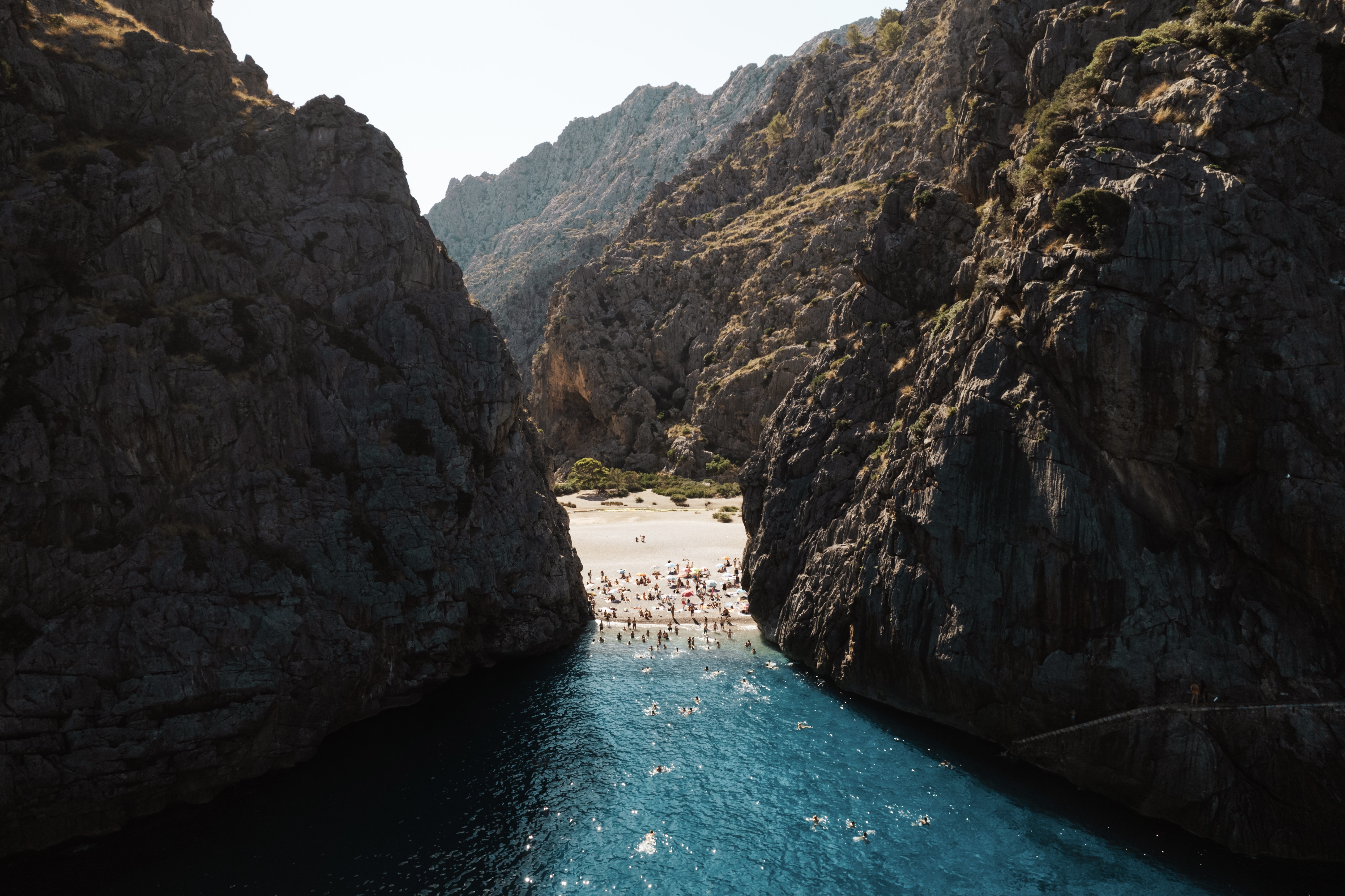 Cinematic coastal canyon beach with crystal clear turquoise water