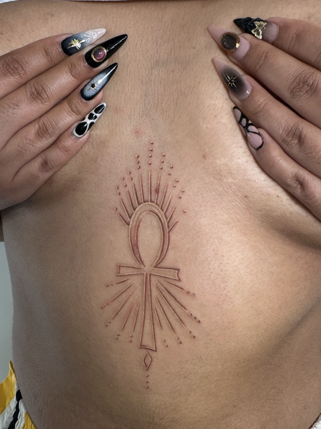 Sacred Red Ink Ankh & Radiating Sunbeam Sternum Tattoo by Justine Almaraz