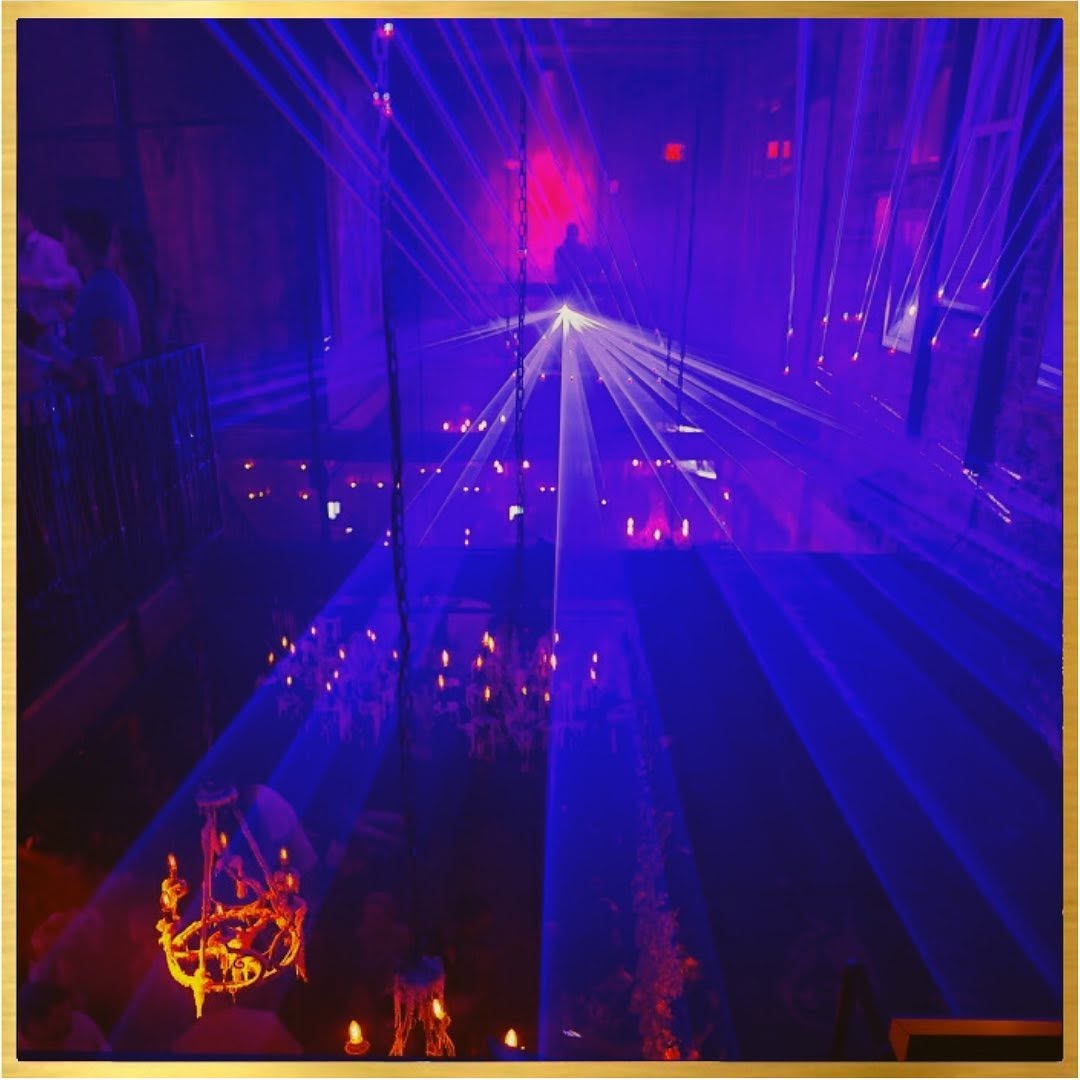 Laser light spectacle illuminating chandeliers and the dancefloor from the mezzanine