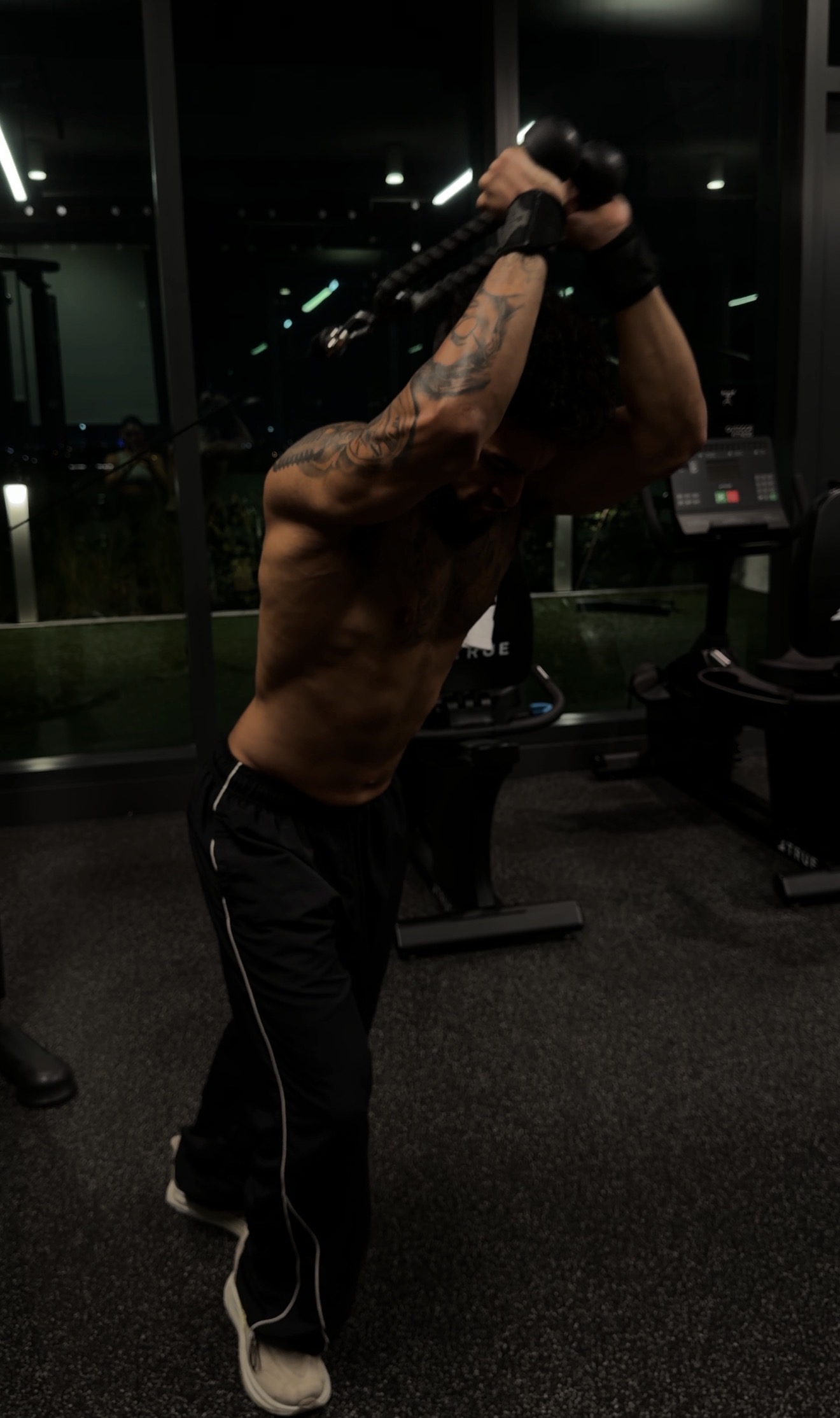 Athlete training cable triceps in a dark aesthetic gym