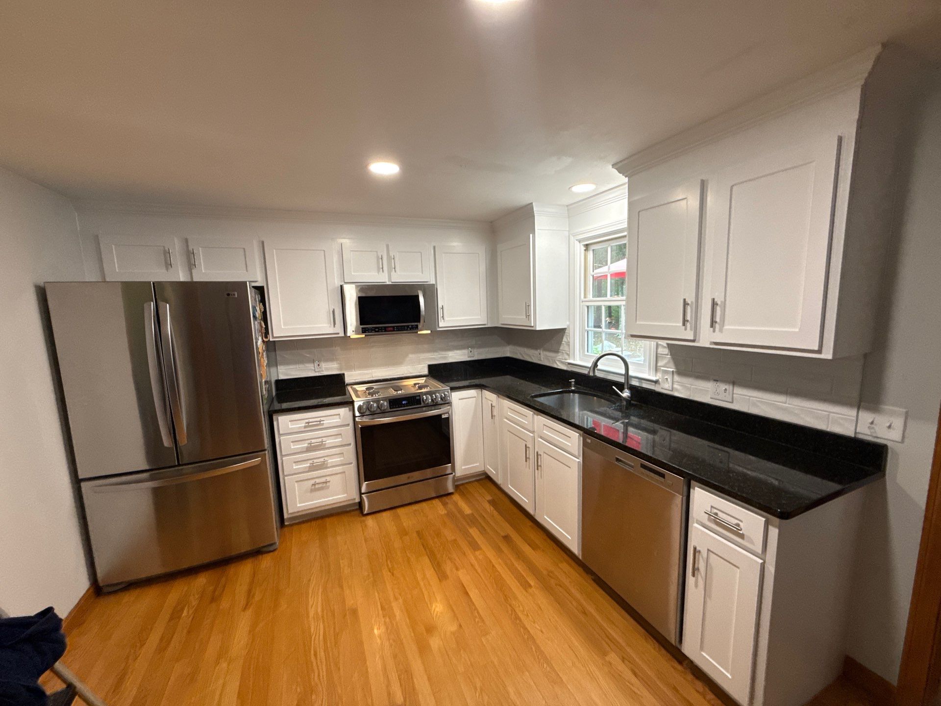 After cabinet painting: factory smooth crisp white painted cabinets, sleek modern bar pulls, and crown molding