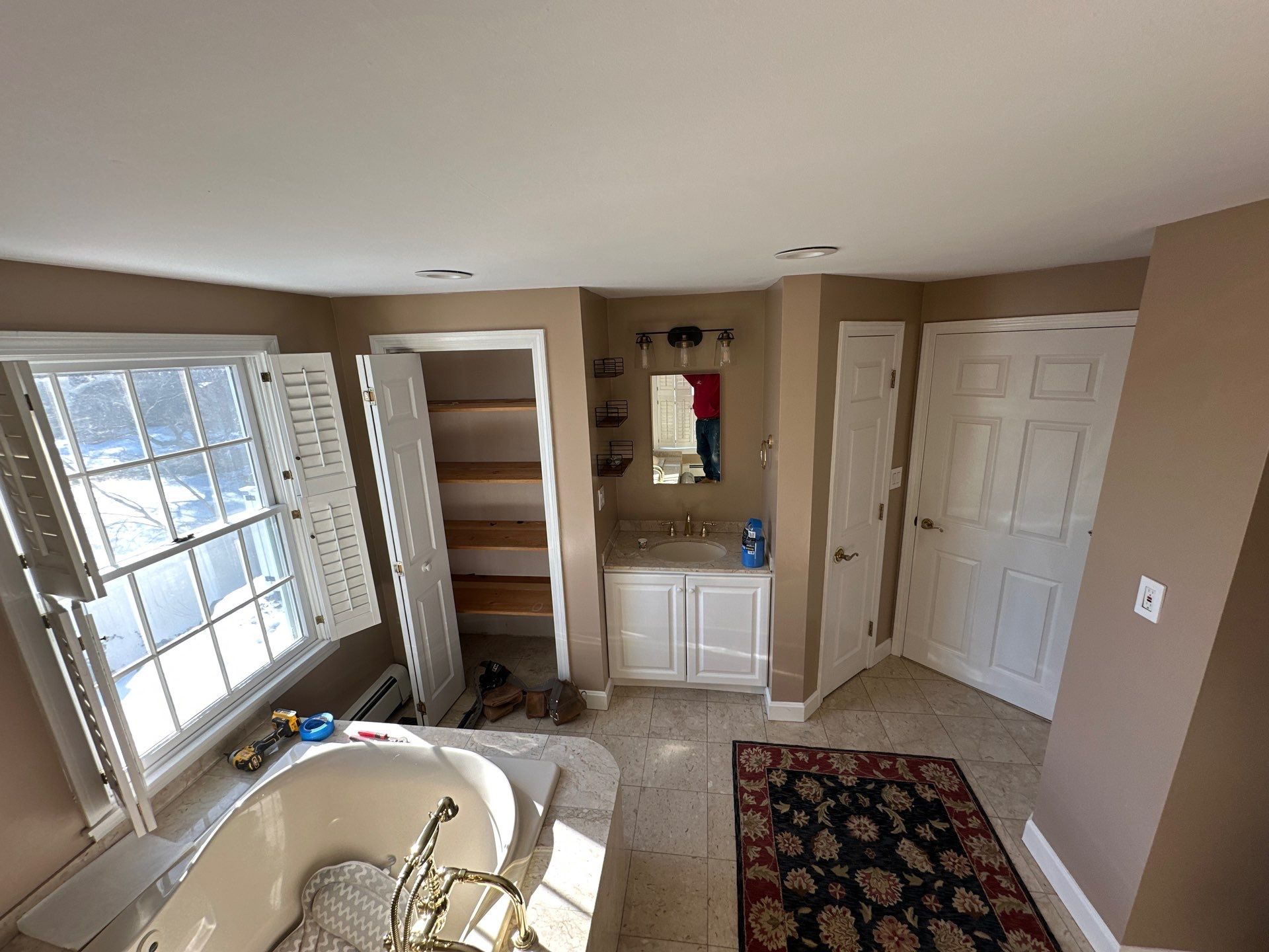 Before remodel: dated small single sink vanity in narrow alcove with brown walls