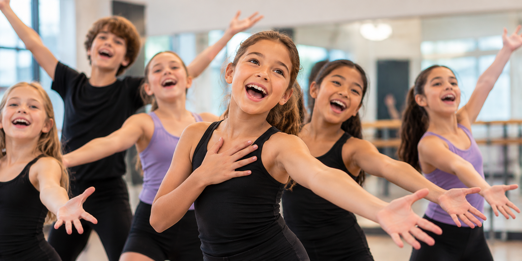 Young dancers smiling and reaching forward joyfully during a dance class