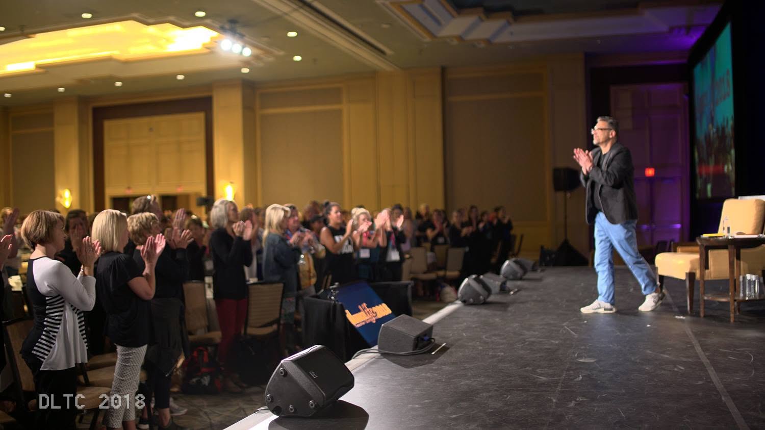 Rhee Gold on stage sharing an inspiring moment with an audience of dance teachers and studio owners