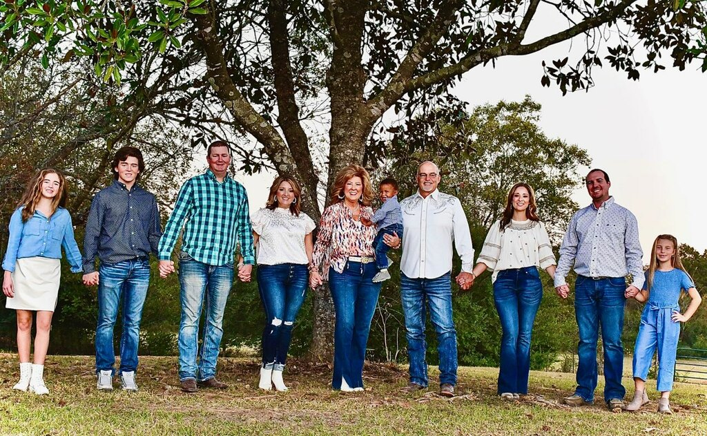 Gus & Judy Biggers Family holding hands together outdoors