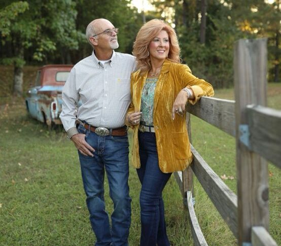 Gus & Judy Biggers by the wooden fence