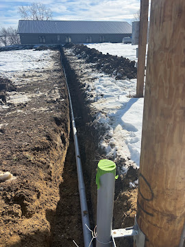 Water line trenched in alongside a livestock barn in winter, Northeast Kansas