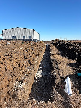 Gallery rock bedded trench beside metal building, Dylan Busey & Co Excavation